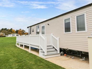 A mobile home with a deck and grass area at Kelly's Retreat in Scarborough