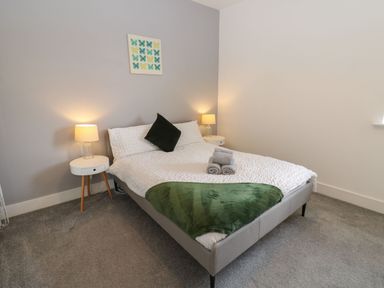 A bedroom with a bed and bedside tables at Harbourside Apartments Whitehaven
