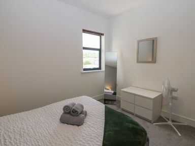 A bedroom with a bed and mirror at Harbourside Apartments in Whitehaven