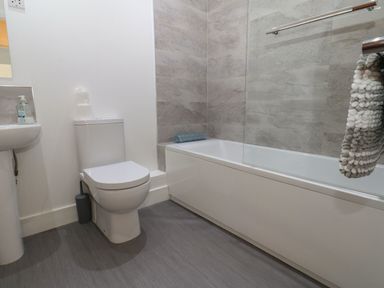A bathroom with a sink, toilet, and bathtub at Harbourside Apartments in Whitehaven