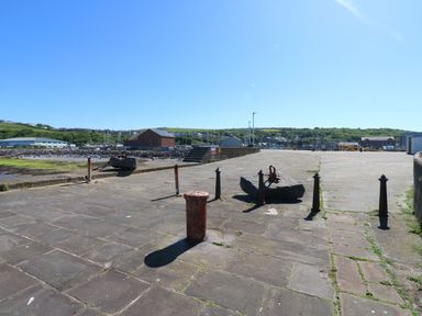 A view of a dock area with an anchor and bollards at Harbourside Apartments in Whitehaven