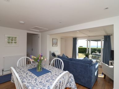 A living room with a dining area and sofa at Stella Maris in Torpoint