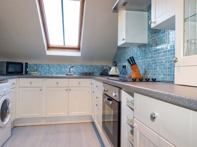 A kitchen with appliances and a window at The Stables in Falmouth