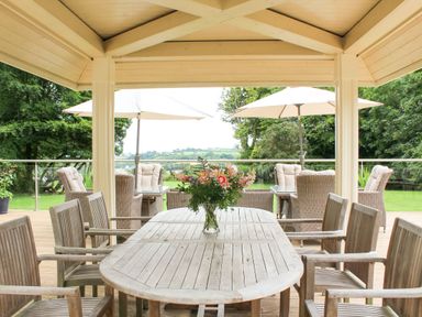 An outdoor patio with a table and chairs at Horseshoe Cottage Budock Water near Falmouth