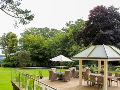 An outdoor area with seating and a gazebo at Horseshoe Cottage Budock Water near Falmouth