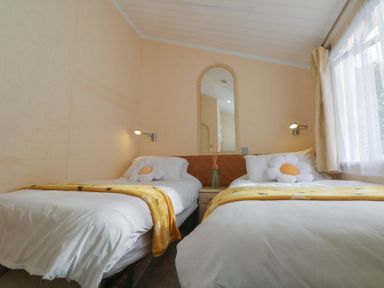 A bedroom with two beds and a mirror at Labernum in Lytham St. Annes