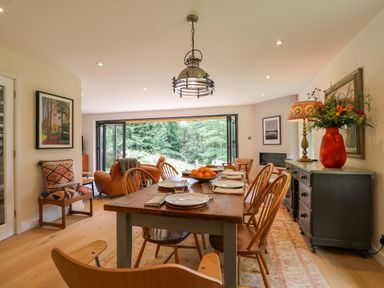 A dining room with a table and chairs at Lakeside Lodge Witherenden Hill near Burwash