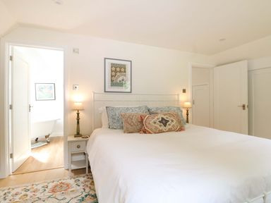 A bedroom with a bed and artwork at Lakeside Lodge in Witherenden Hill near Burwash