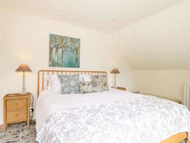 A bedroom with a bed and nightstands at Lakeside Lodge in Witherenden Hill near Burwash