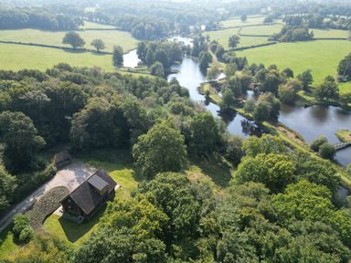An aerial view of a house near a lake at Lakeside Lodge in Witherenden Hill near Burwash