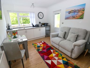 A kitchen with a sofa and dining area at Pinecroft Annex Stepaside near Saundersfoot