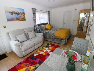 A living room with a bed and sofa at Pinecroft Annex Stepaside near Saundersfoot