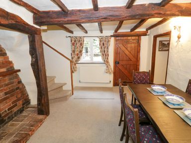 A dining room with a wooden table and chairs at Fern Cottage in 