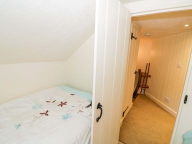 A bedroom with a bed and a door at Fern Cottage