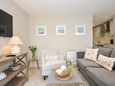 A living room with a sofa and armchair at Evelyn in Looe
