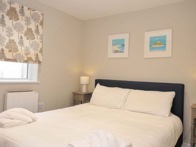 A bedroom with a bed and bedside table at Evelyn in Looe