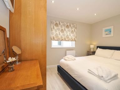 A bedroom with a bed and a bedside table at Evelyn in Looe