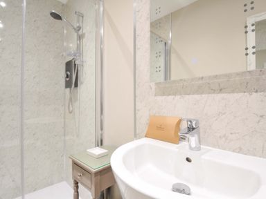 A bathroom with a shower and sink at Evelyn in Looe