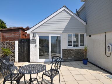 An outdoor seating area with chairs and table at Evelyn in Looe