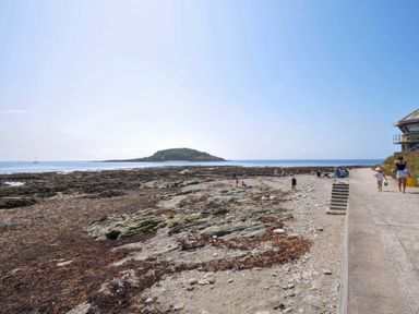 A beach with rocks and people at Evelyn in Looe