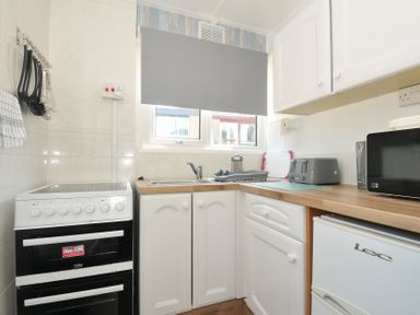 A kitchen with an oven, sink, and appliances at 13 Hillside in Bude