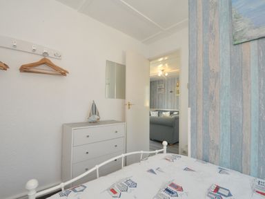 A bedroom with a bed and dresser at 13 Hillside, Bude