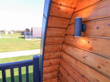 Wooden wall with a light fixture and view of cabins at New Pod Kilkhampton