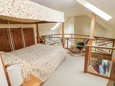 A bedroom with a bed and rocking chair at The Dovecote in Llanychaer near Fishguard