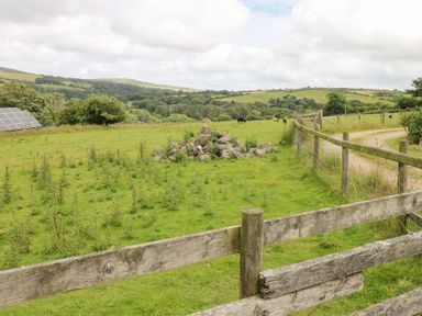 An outdoor scene with a field, solar panels, and a fence at The Dovecote near Llanychaer Fishguard