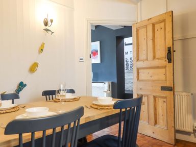 A dining room with a table set for a meal at Captains Cottage Brixham
