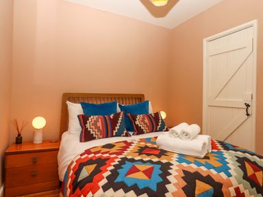 A bedroom with a bed and nightstand at Captains Cottage in Brixham