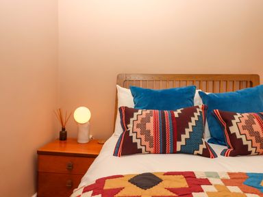 A bedroom with a bed and bedside table at Captains Cottage in Brixham