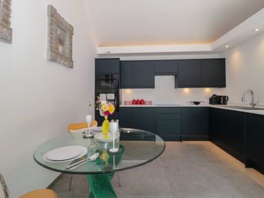 A kitchen with a dining table and chairs at Noflash Malpal in Bishop Sutton