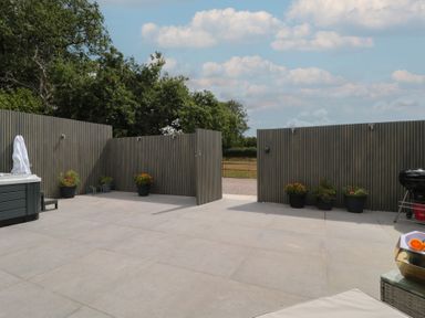 An outdoor area with a hot tub and flower pots at Noflash Malpal in Bishop Sutton