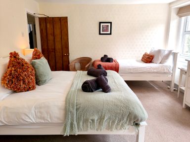A bedroom with two beds and a chair at Bush Nook House in Brampton