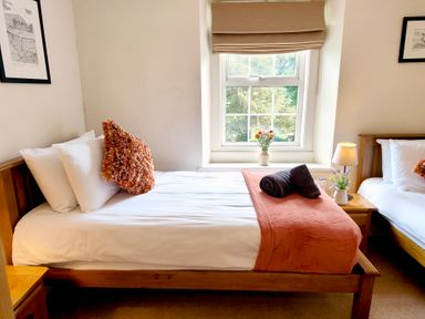 A bedroom with two beds and a window at Bush Nook House in Brampton
