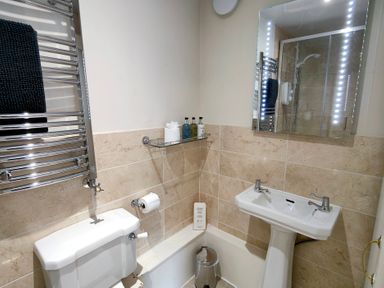 A bathroom with a sink, toilet, and shower at Bush Nook House in Brampton