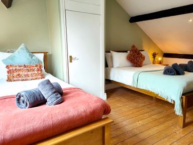 A bedroom with two beds and towels at Bush Nook House in Brampton