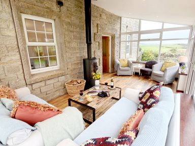 A living room with a coffee table and stove at Bush Nook House in Brampton, Cumbria