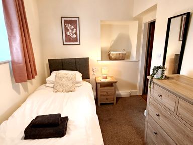 A bedroom with a single bed and bedside table at Bush Nook House in Brampton, Cumbria