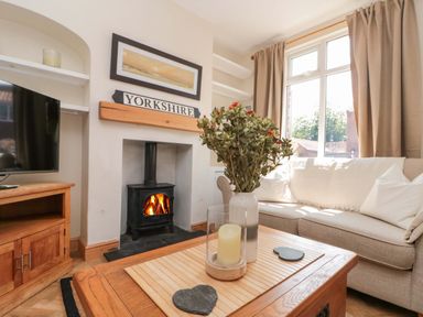 A living room with a sofa and television at Moot Cottage in Driffield