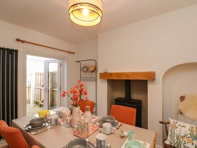 A dining room with a table set for a meal at Moot Cottage in Driffield