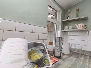 A kitchen with a recipe book open on the counter at Moot Cottage Driffield