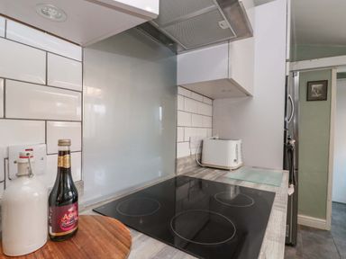 A kitchen with a stove and a toaster at Moot Cottage in Driffield