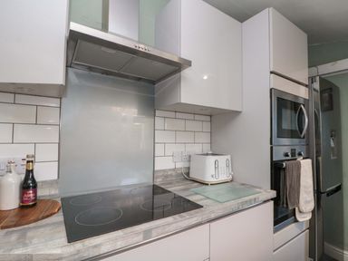 A kitchen with a cooktop and oven at Moot Cottage in Driffield