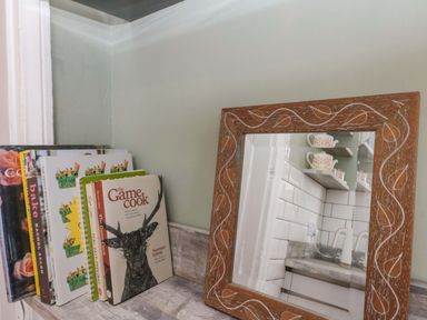 A collection of cookbooks and a mirror in a kitchen at Moot Cottage in Driffield