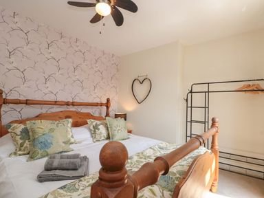 A bedroom with a bed and wardrobe at Moot Cottage in Driffield