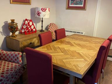A dining room with a wooden table and red chairs at The Bittern in Blakeney, Norfolk