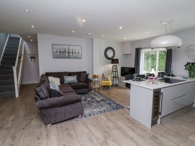 A living room with a sofa and kitchen island at Beach Hideaway