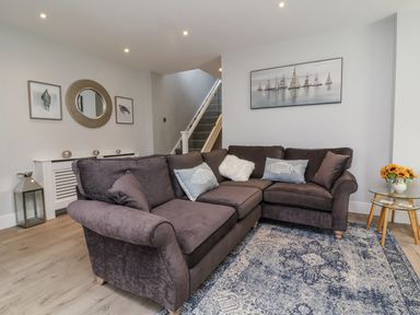 A living room with a sofa and carpet at Beach Hideaway